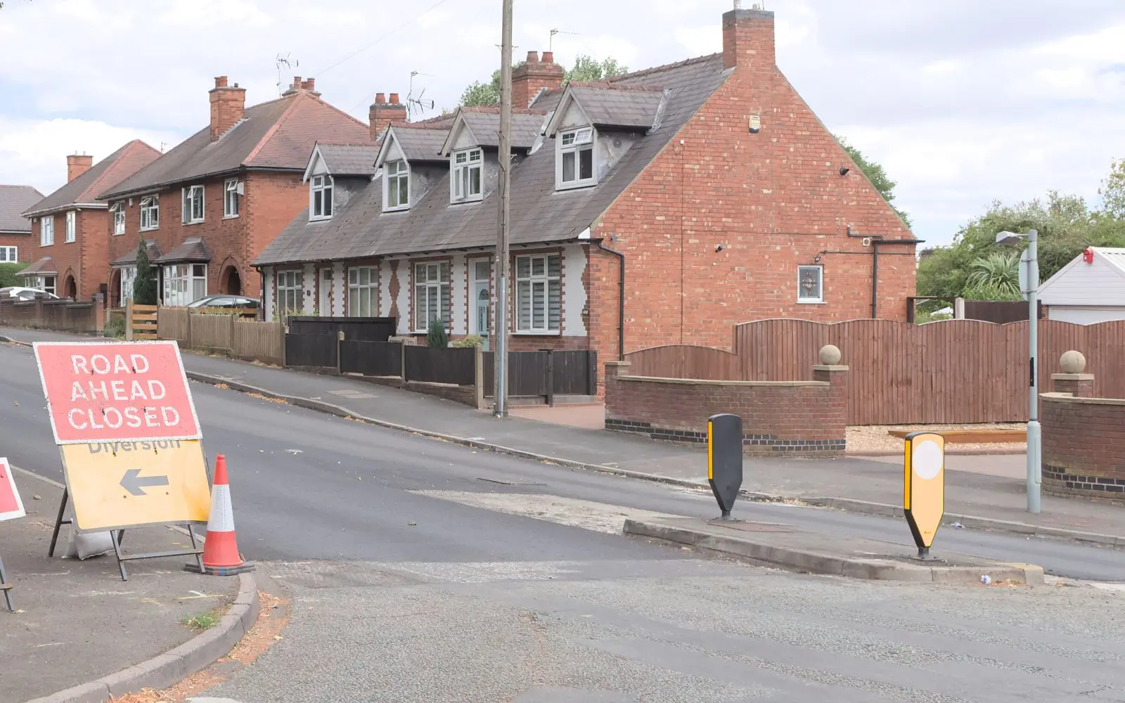 Road ahead closed and diversion signs at the entrance to a residential street